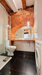 a bathroom with a toilet and a sink and a mirror at CityNest Apartments in Krakow +41 photos