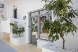ein Haus mit zwei Bäumen vor einer Tür in der Unterkunft Zas Studios in Naxos Chora