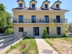 Una casa antigua con un balcón encima. en Résidence de la gare, chambre meublée, en Longjumeau