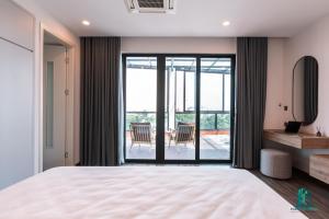 een slaapkamer met een groot bed en een balkon bij Luxe Paradise Residence 5 Tu Hoa in Hanoi