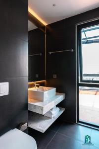 a bathroom with a white sink and a window at Luxe Paradise Residence 5 Tu Hoa in Hanoi