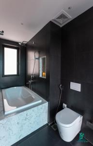 a bathroom with a bath tub and a toilet at Luxe Paradise Residence 5 Tu Hoa in Hanoi