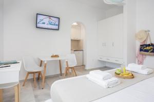 a white room with a bed and a table at Zas Studios in Naxos Chora