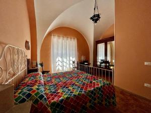 1 dormitorio con 1 cama con colcha colorida en Da Concy, en Fossacesia