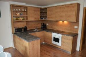 a kitchen with wooden cabinets and a counter top at Apartments Arh in Bohinj