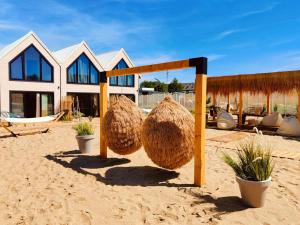 una casa con due grandi cesti di fieno nella sabbia di Lulu Holiday Resort a Mielno