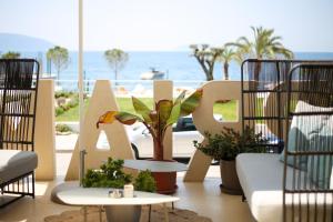 una señal para un complejo de playa con plantas. en Priam Hotel Luxury Resort, en Vlorë