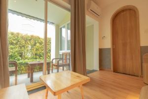 a living room with a table and a large window at Tây Tiến Bungalow in Phú Quốc