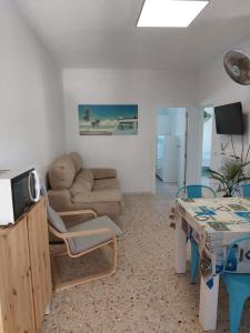 sala de estar con sofá y mesa en CasaMaria 50 metros de la playa, en El Palmar