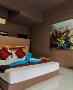 a bedroom with a bed with a painting on the wall at Wirason Residence in Lamai