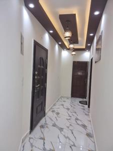 a hallway with a black door and a marble floor at Coral House in Hurghada