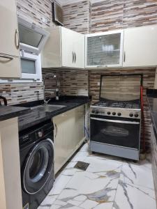a kitchen with a stove and a washing machine at Coral House in Hurghada