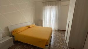 una camera da letto con un letto con lenzuola gialle e una finestra di La Finestra sul Borgo a Campomarino