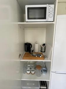 a white microwave oven sitting on top of a shelf at Gårdshus - best location in the center of Gränna in Gränna