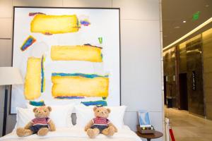 two teddy bears sitting on top of a bed at Four Points By Sheraton Guilin Lingui in Guilin