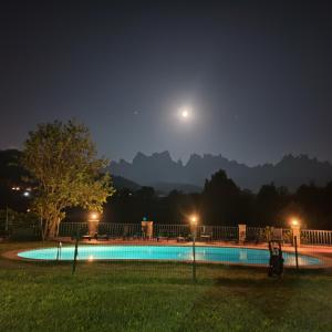 a moon over a swimming pool at night at Cal Poldo in Marganell
