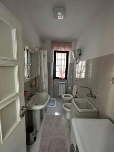 Baño blanco con 2 aseos, lavamanos y aseo en Da Concy, en Fossacesia