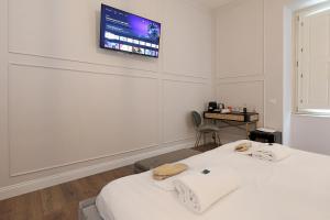 Pokój z dwoma łóżkami i telewizorem na ścianie w obiekcie Rome Plaza Suites, Luxury Collection w Rzymie