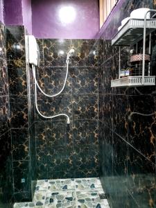 a bathroom with a shower with a black marble wall at Wirason Residence in Lamai