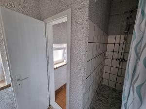 una puerta abierta a un baño con nevera en Gästewohnung in der Nähe des Ferienparks Plötzky, en Plötzky