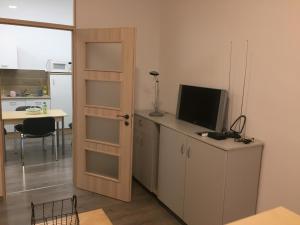 a room with a door open to a kitchen with a television at City Center apartment in Pécs +6 photos