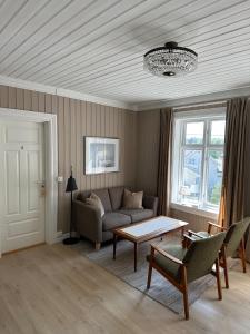 a living room with a couch and a table at Det Gamle Hotellet Guesthouse in Reine