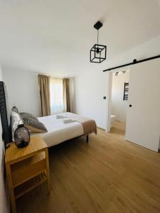 a bedroom with a bed and a table and a door at El Apartamento de la Colegiata in Vigo