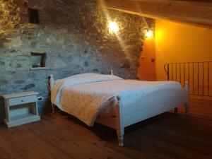 a bedroom with a bed in a stone wall at La Maison D' Amelie in Fenis