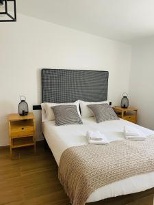 a bedroom with a large white bed with two night stands at El Apartamento de la Colegiata in Vigo