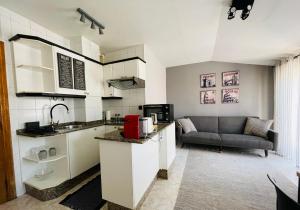 a kitchen and a living room with a couch at El Apartamento de la Colegiata in Vigo