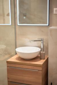 a bathroom with a white bowl sink on a wooden counter at Canta Amore II in Zadar