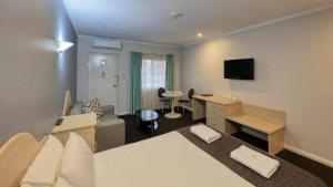 Habitación de hotel con cama y escritorio en Charles Rasp Motor Inn & Cottages en Broken Hill