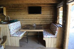 CorscombeにあるKnapp Farm Glamping Lodge 1のキャビン内のテーブルとテレビ付きの部屋