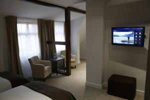 um quarto de hotel com uma televisão na parede em Hotel Chopin Bydgoszcz em Bydgoszcz