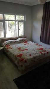 Un dormitorio con una cama con flores rojas. en göl manzarali ılıcaya ve göle 200m uzaklikta, en Boyalıca