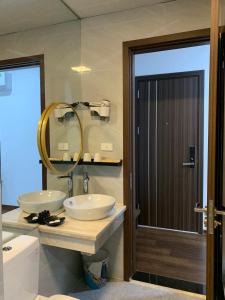 a bathroom with two sinks and a mirror and a toilet at Anika Hotel in Ha Long