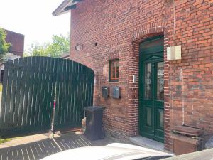 a brick building with a green door and a trash can at Fewo Itzehoe in Itzehoe