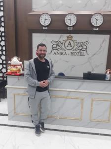 a man standing in front of a counter with clocks at Anika Hotel in Ha Long
