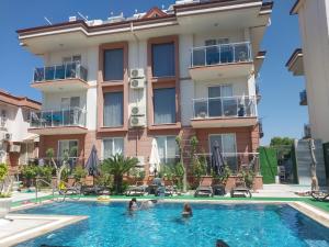 a hotel with a swimming pool in front of a building at kerim apart tatil evleri in Fethiye