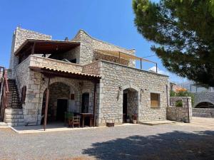 a stone house with a balcony on top of it at Torre di Maina in Kharoúdha