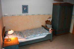 ein Schlafzimmer mit einem Bett, einem Schrank und einer Lampe in der Unterkunft Ferienhof Veit 
