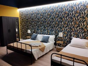 una camera da letto con due letti e una parete con carta da parati di PONTEVECCHIO Accomodation a Ragusa