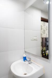 a white bathroom with a sink and a mirror at Marigold At Nest in Gachibowli