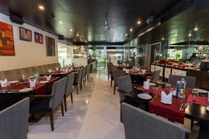 a dining room with tables and chairs and a restaurant at Svenska Design Hotel Andheri in Mumbai