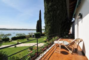 ławka na balkonie z widokiem na wodę w obiekcie Villa Cecilia w mieście San Felice del Benaco