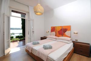 sypialnia z dużym łóżkiem i dużym oknem w obiekcie Villa Cecilia w mieście San Felice del Benaco