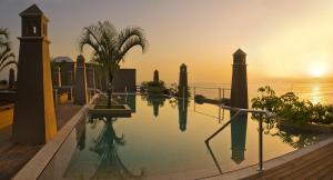 a pool with a view of the ocean at sunset at Hotel Playa Calera in Valle Gran Rey
