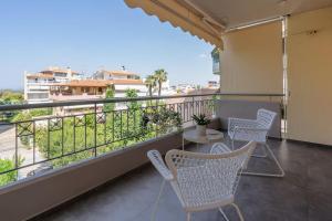 a balcony with chairs and a table and a view at Stylish 1BD Apt in Elliniko in Athens
