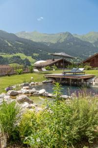 a garden with a pond and a bridge and mountains at Lieblingsplatzl inklusive kostenfreiem Eintritt in die Alpentherme in Bad Hofgastein