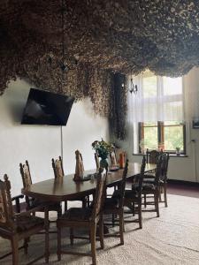 a dining room with a wooden table and chairs at Stara Szkoła in Krempna